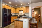 Kitchen with granite counters, stainless appliances, and extra bar seating